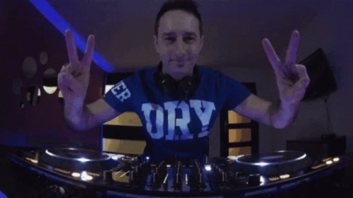 a dj spins around his turntable with peace signs in the foreground