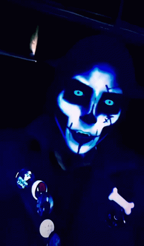 a person in dark colors has glowing makeup and dark eyes