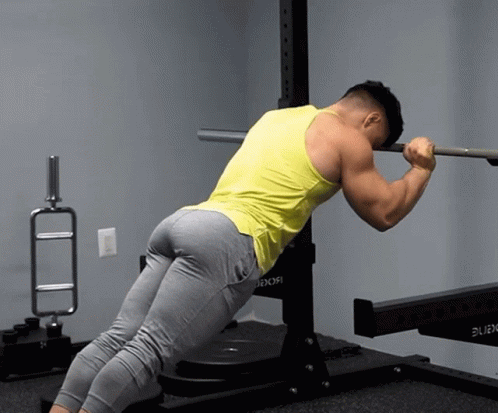 man in mid - squat lifts one arm to the side