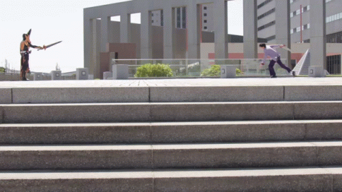 two people are walking down a staircase that has cement steps