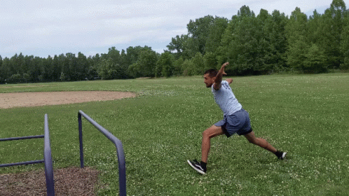 a man is jumping in the air to catch a frisbee