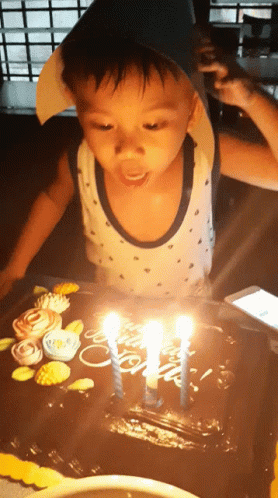 the  is celeting his birthday with his blue candles