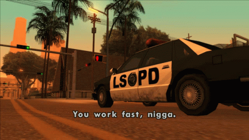 a police car is on the street in front of a palm tree