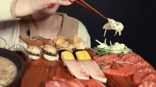 a girl is holding a pair of chopsticks above her food