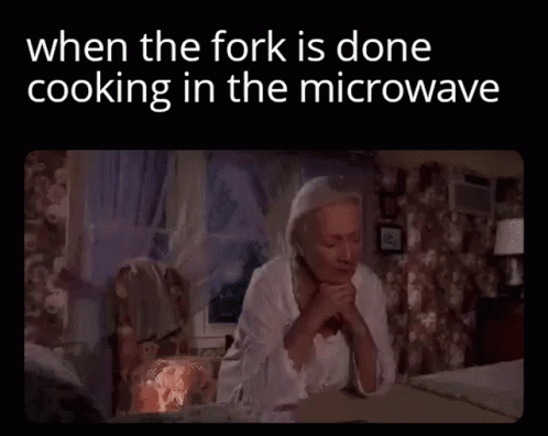 an old po with a woman sitting at a table, holding her hands over her face and the text, when the fork is done cooking in the microwave