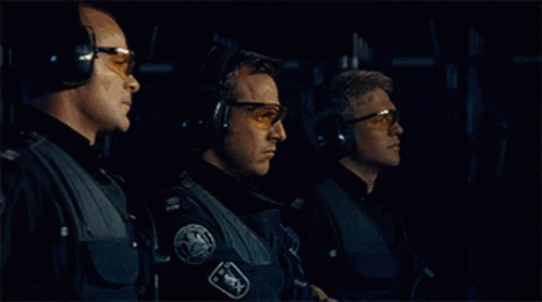 several guys wearing glasses standing in a dark space