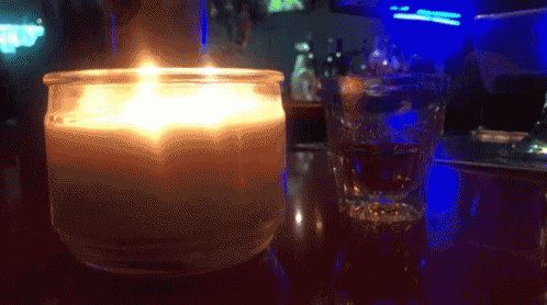 a blue colored candle sits on top of a bar table