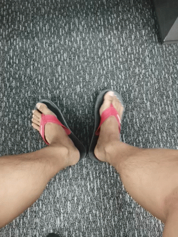 a person's feet with sandals on and a cell phone