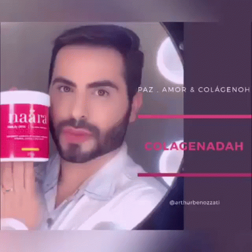 a bearded man holding a bottle of hair color