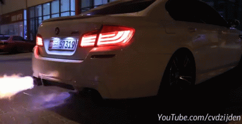 a white car is being sprayed with blue light