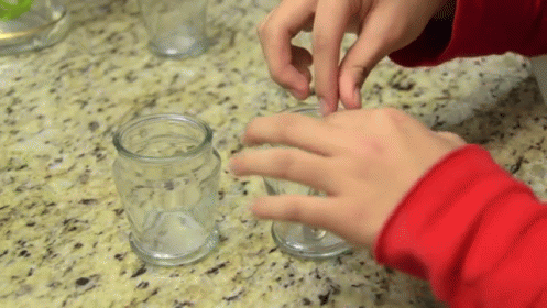 two hands wearing blue touching each other with three different beakers