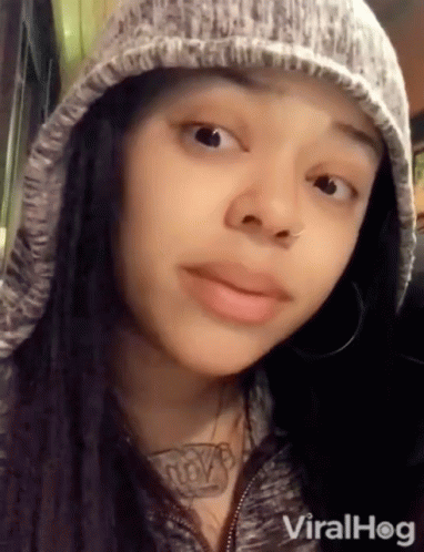 a woman with a beanie and piercings looking at the camera