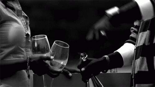 a person holding a wine glass next to a man with a wrist strap