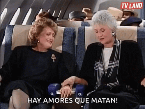 two ladies talking on airplane seats next to each other