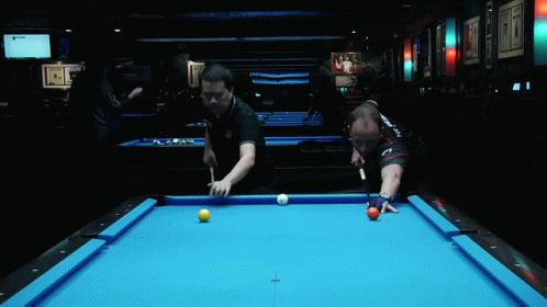 two men playing pool at an indoor restaurant
