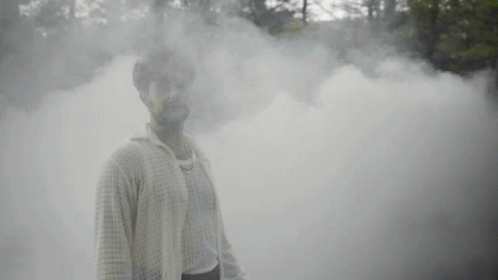 a man standing in a smoke bomb pose