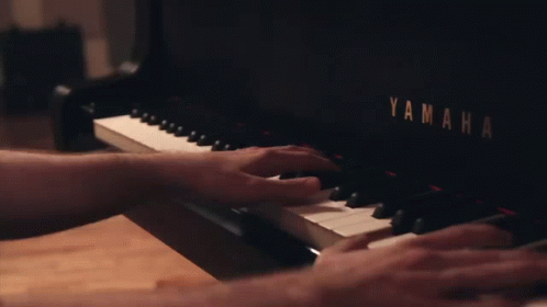 the hands are playing a piano with writing on it