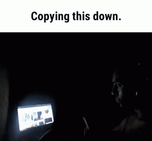 a man with an open laptop on his lap that is sitting in the dark