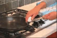 a hand in blue gloves is cleaning the stove