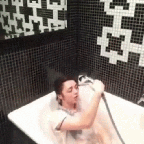 the woman is in a tub with the hair dryer