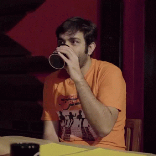 a man is drinking from a black coffee mug
