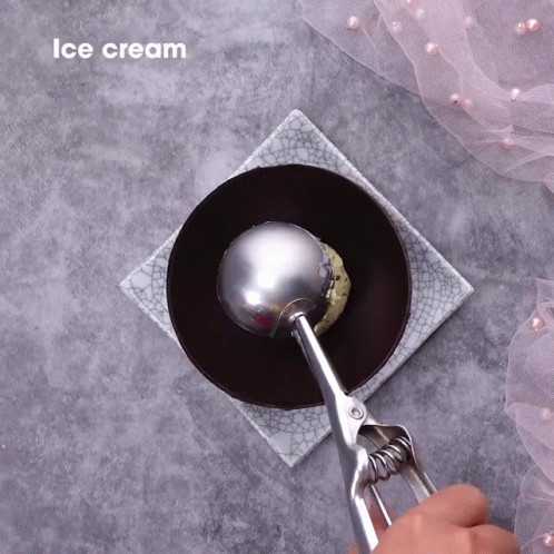 a pair of blue gloves is using a ball shape spoon to open a plate