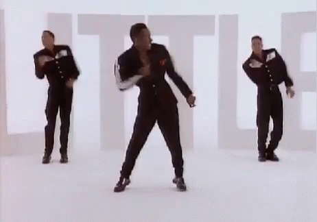 three men in black clothes are dancing in the room