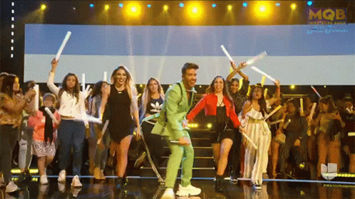a man in a green suit on stage with a group of people
