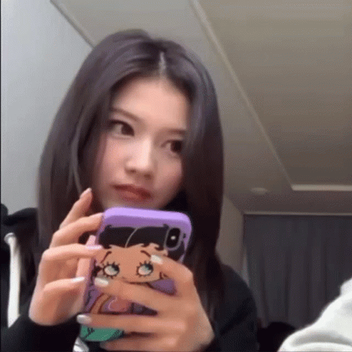 a girl looking into her cellphone while she's taking a picture