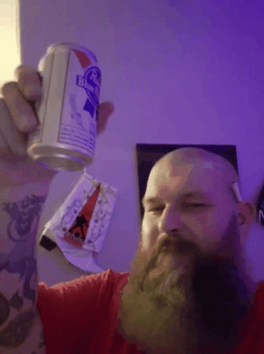 man with beard and white beard holding up a red and blue can