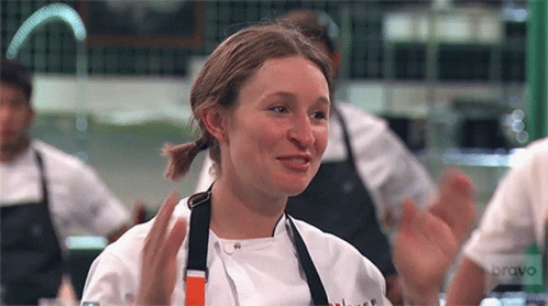 a young woman dressed in a chef uniform is on the television screen