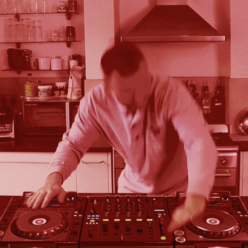 a man in a house mixing music on the sound board