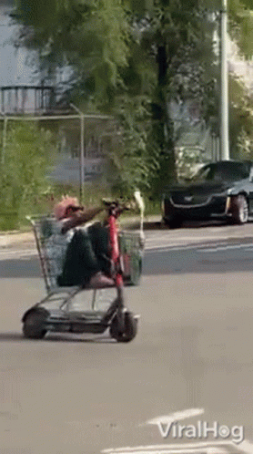 two people riding luggage carts in a parking lot