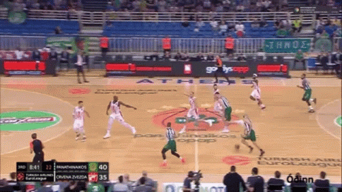 several men on opposite teams playing basketball in a sports arena