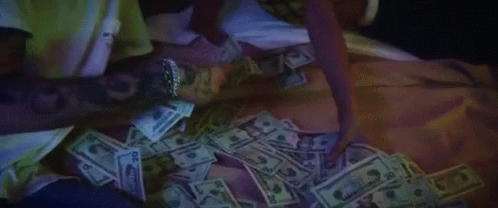 a person laying on a bed with many cash