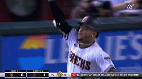 the baseball player raises his hand to catch a ball