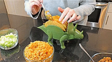 someone making a dinosaur cake in the kitchen