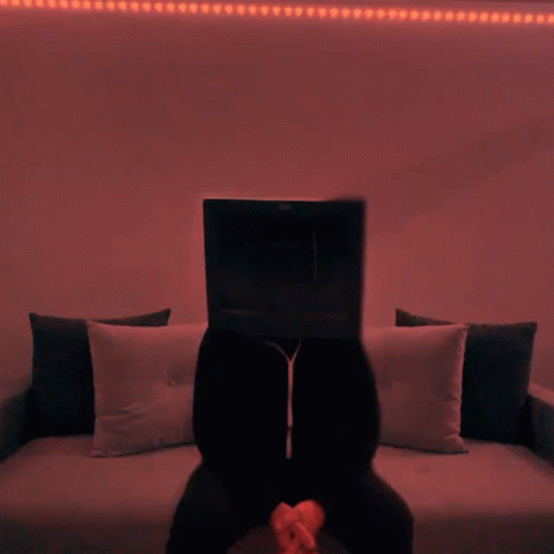 a man sitting in front of a laptop on a couch