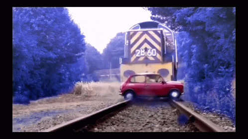 an old timey pograph of a purple car on railroad tracks