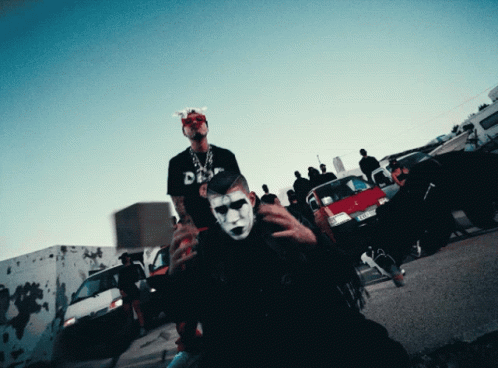 two people with masks posing in front of a crowd