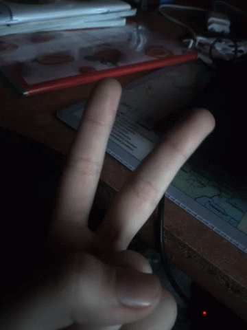 a person's fingers on a desk making the v sign