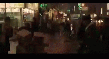 a blurry image of people walking down a street at night