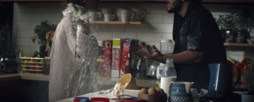 two men in an old fashion kitchen sprinkling flour