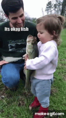 there is a small  sitting with a little girl holding a fish