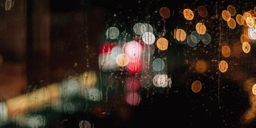 a city street seen through a window with raindrops