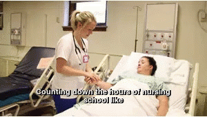 a nurse touching the hand of a patient who is laying in a bed