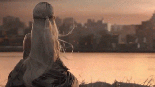 a woman with long white hair looking out over a city