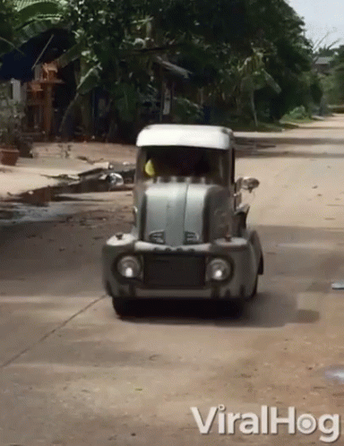 a street view looking at an old truck driving down a road