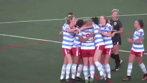 group of soccer players huddle together on a field