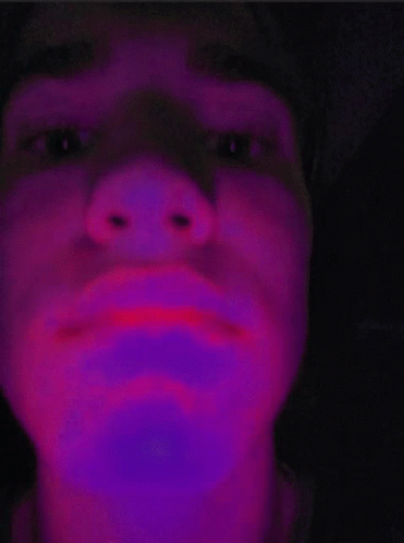 a man is shown with pink light in his face